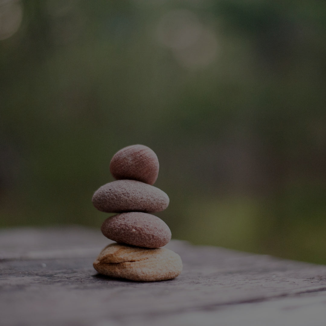 Stack of stones balanced on a rock with a blurred natural background