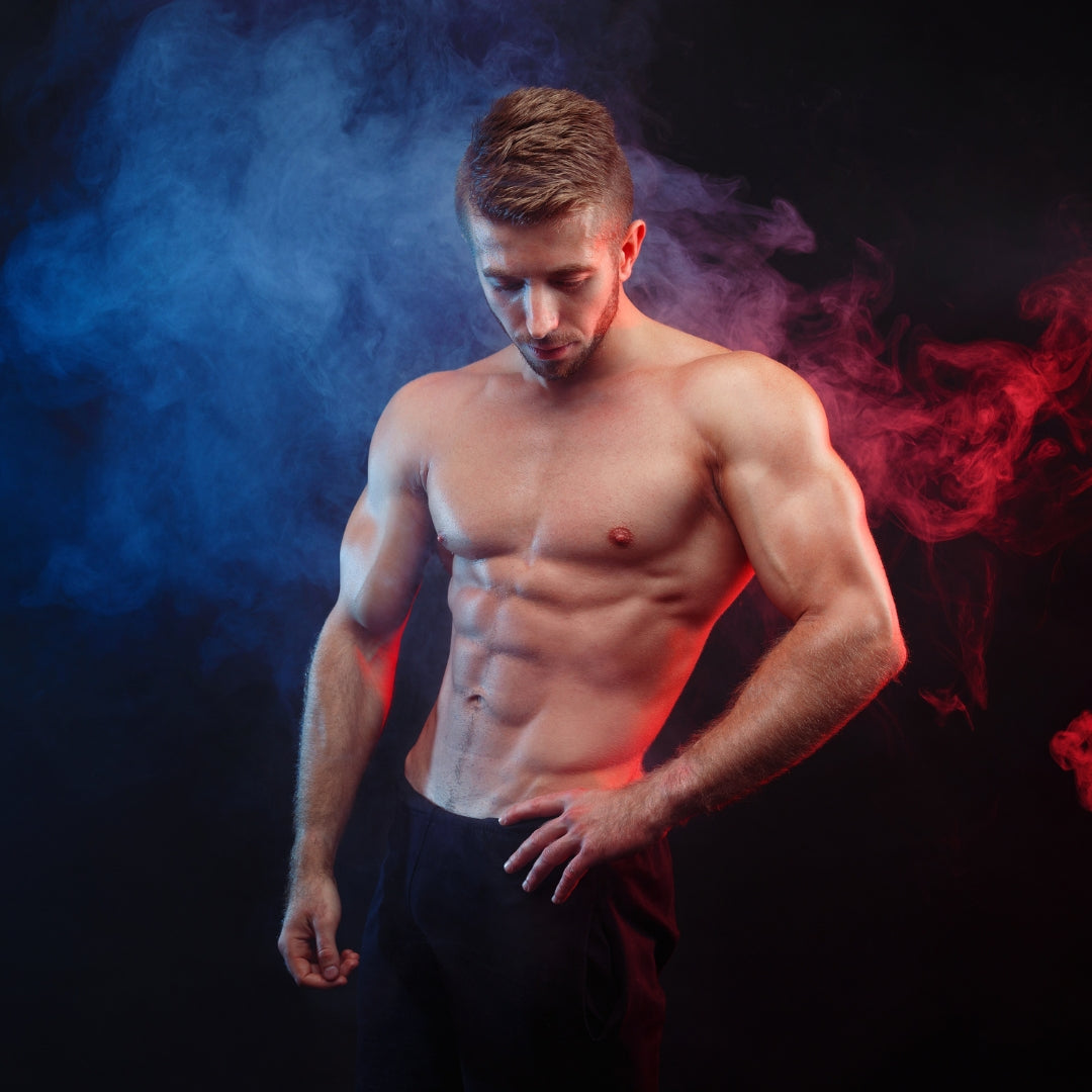 Muscular man posing against a dark background with colorful smoke effects