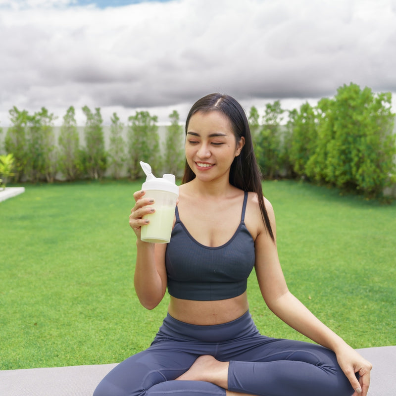Woman in athletic wear sitting outdoors with a blurred background
